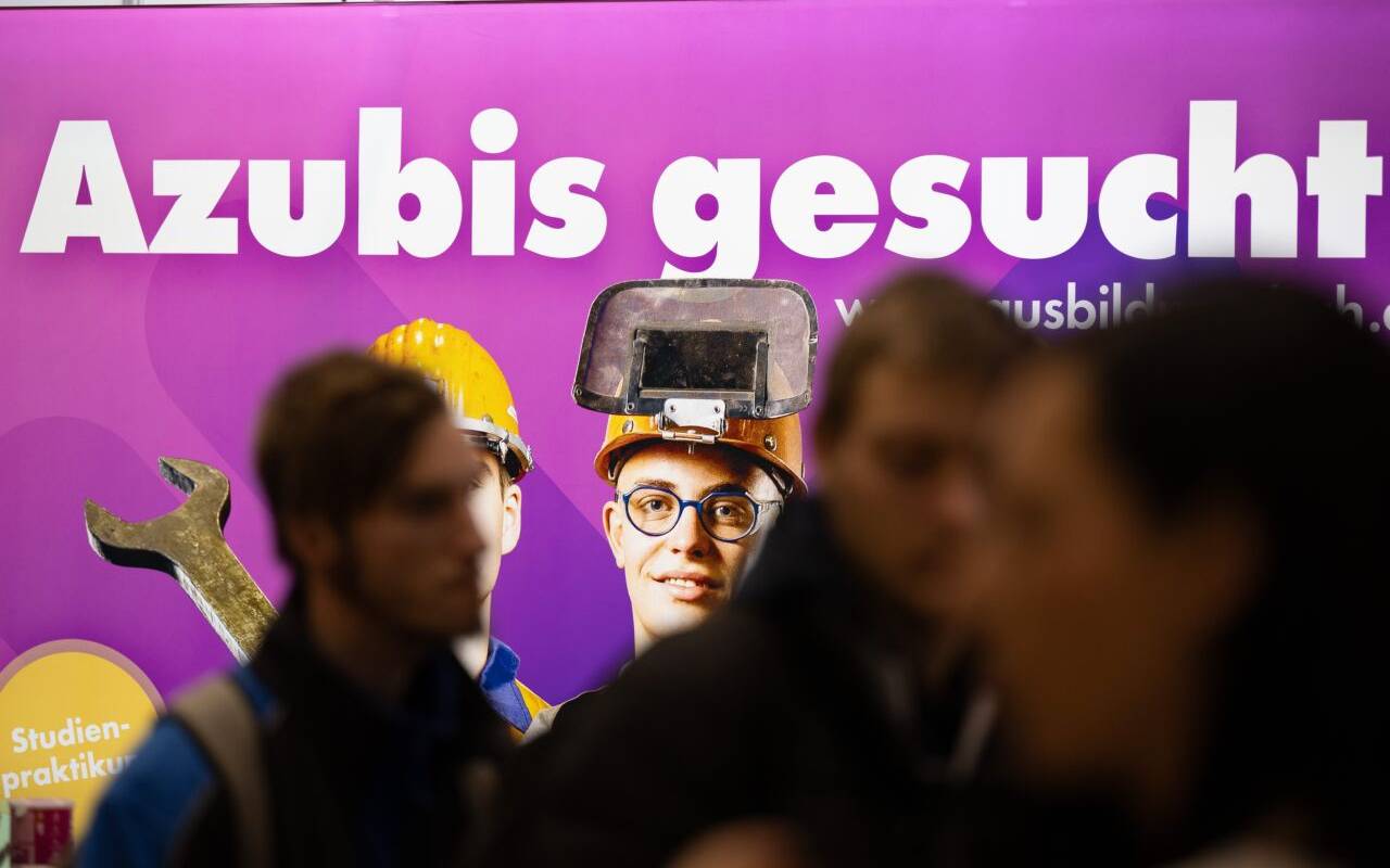 Besucher stehen auf der Jobmesse "KarriereStart" vor dem Schriftzug "Azubis gesucht"
