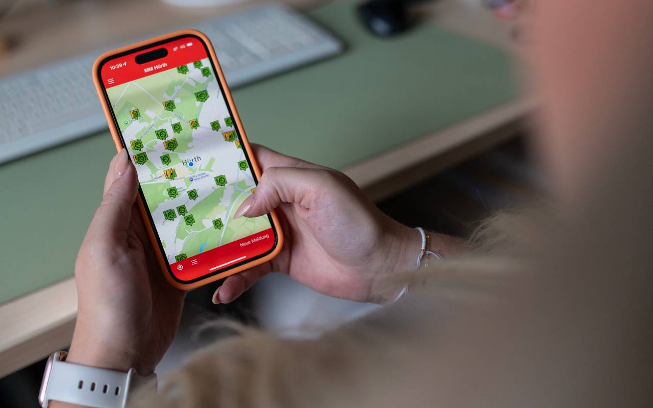 Handy mit der Mängelmelder-App Hürth