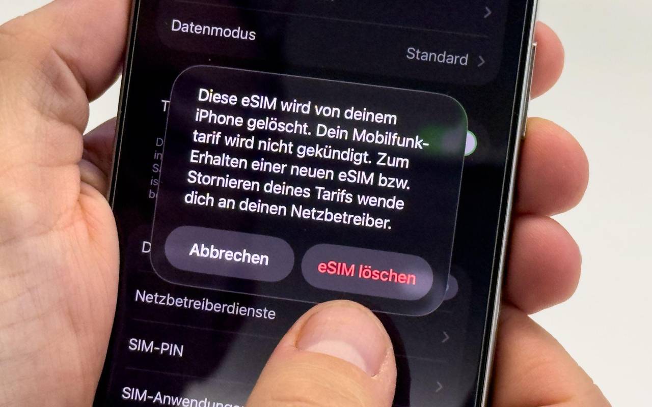 Ein Mann aendert die SIM-Karten-Einstellungen auf einem iPhone