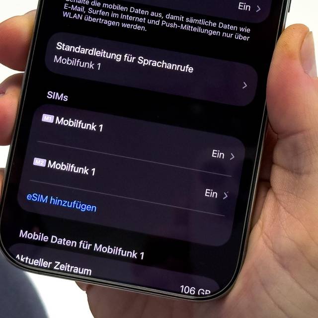 Ein Mann aendert die SIM-Karten-Einstellungen auf einem iPhone
