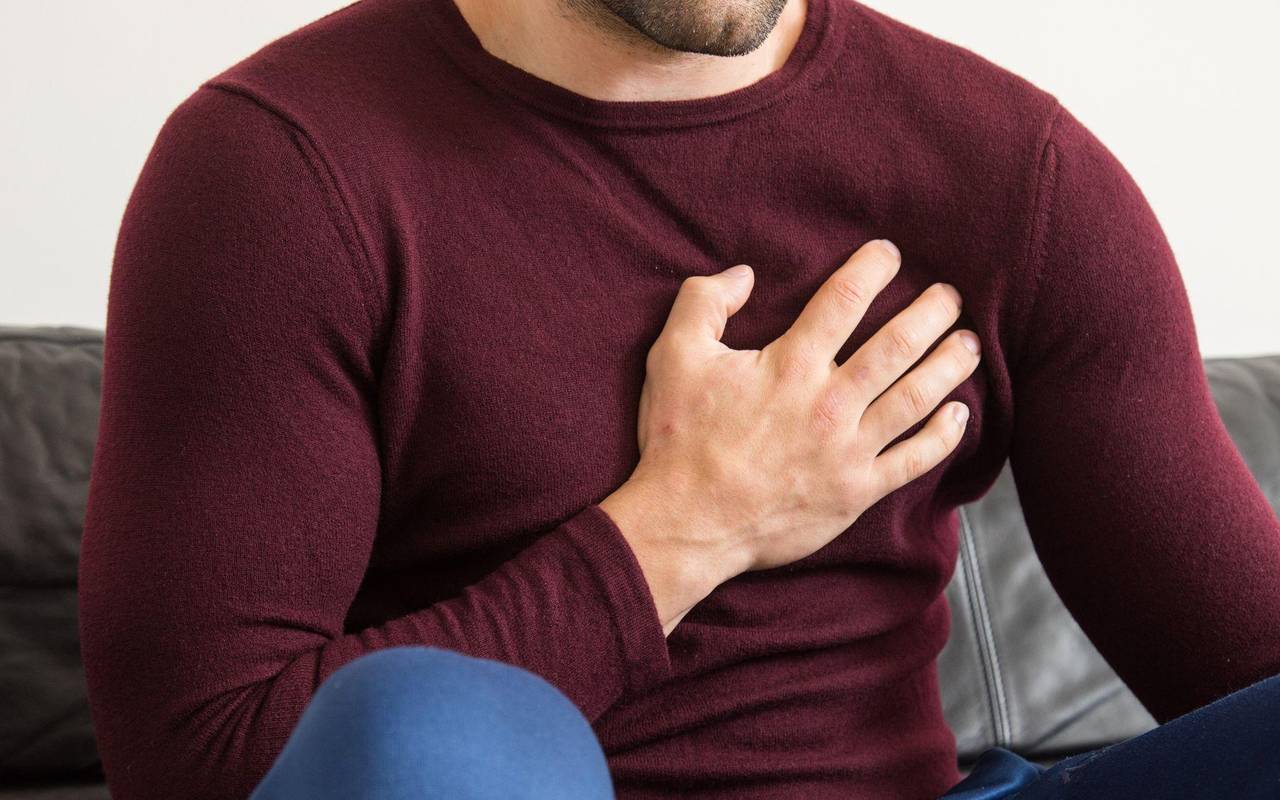 Ein Mann hält sich vor Brustschmerzen die Brust