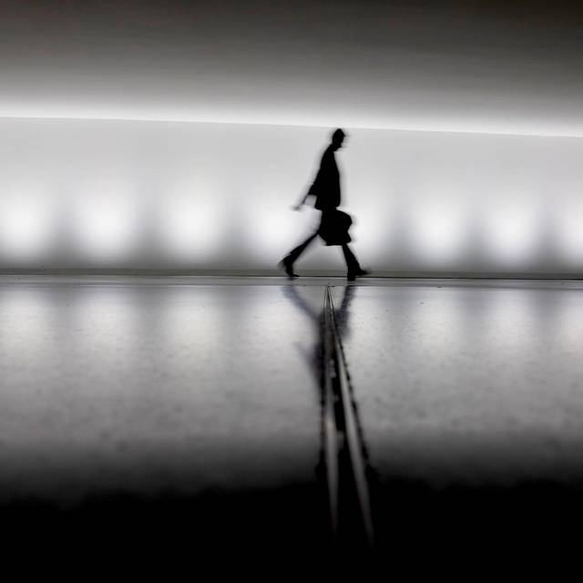 Eine Person geht an einem Gebäude vorbei