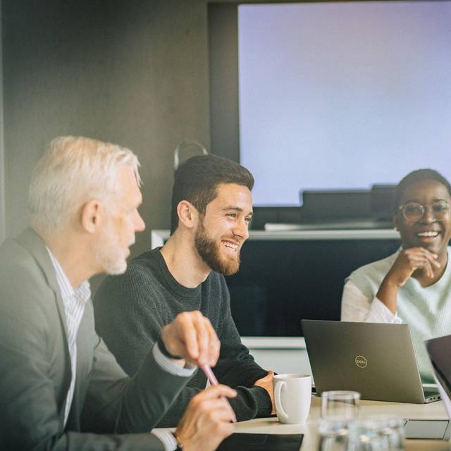 Eine Gruppe Kolleginnen und Kollegen arbeitet an Projekt