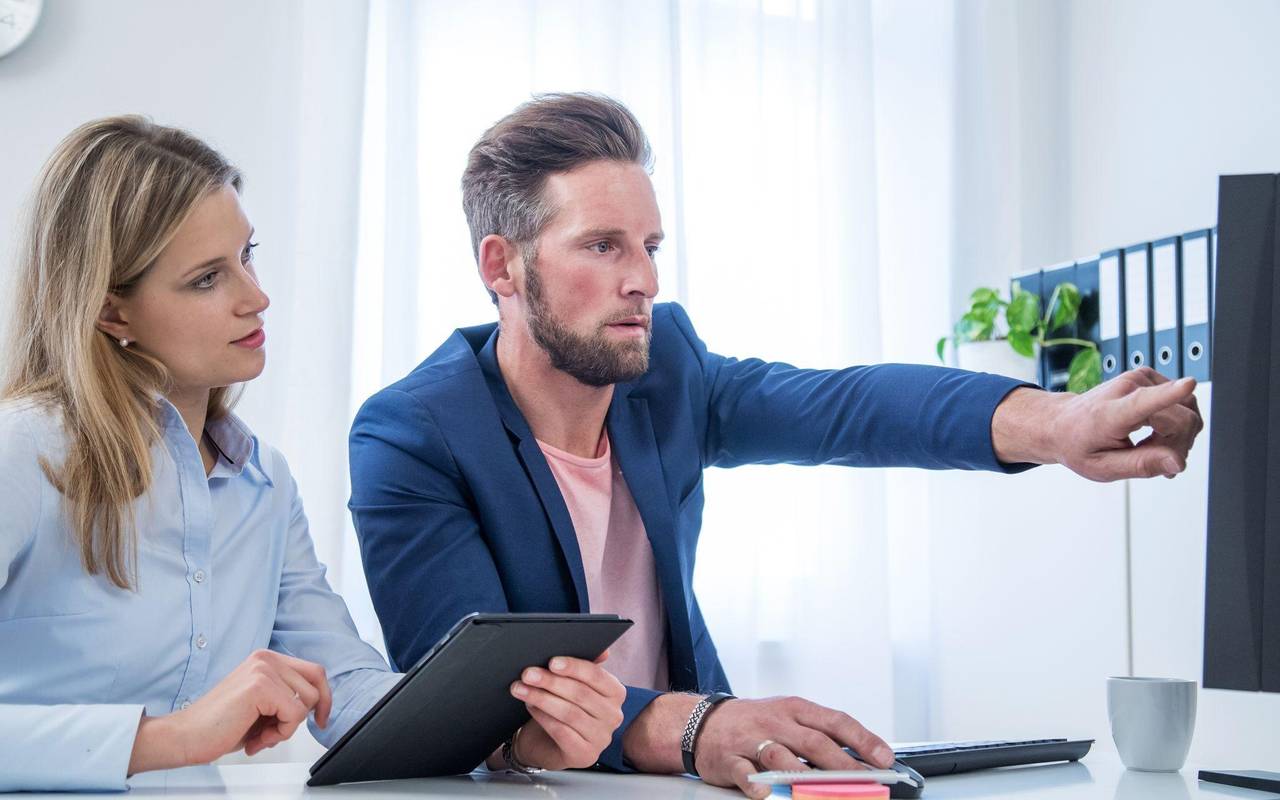 Kollegen blicken auf einen Monitor