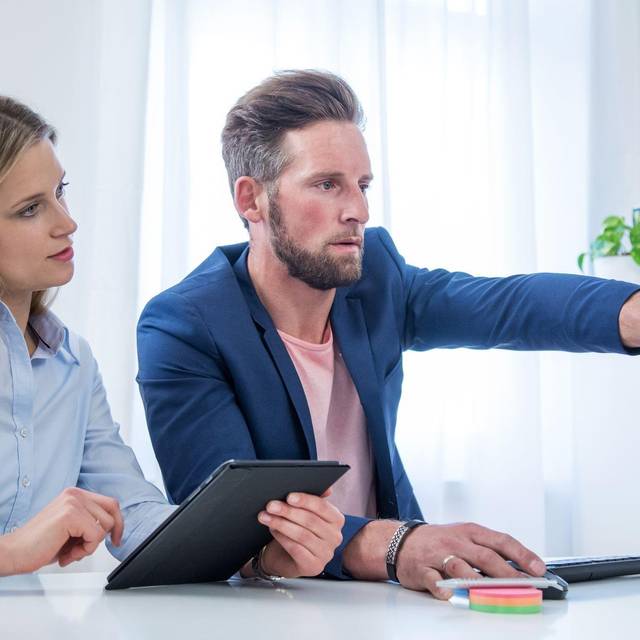 Kollegen blicken auf einen Monitor