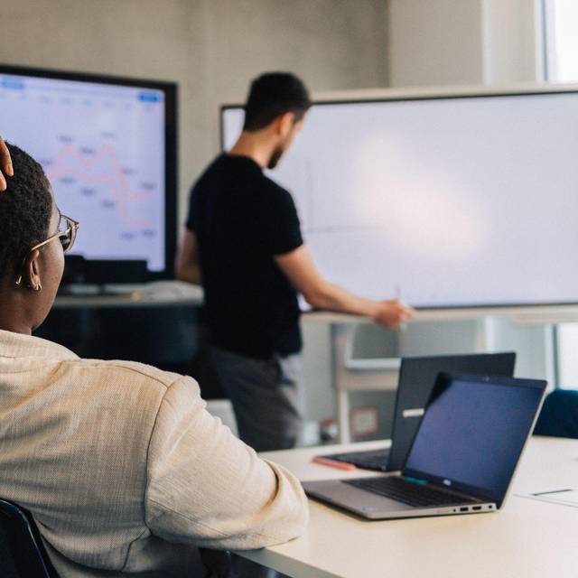 Eine Faru fasst sich an den Kopf in einem Meetingraum