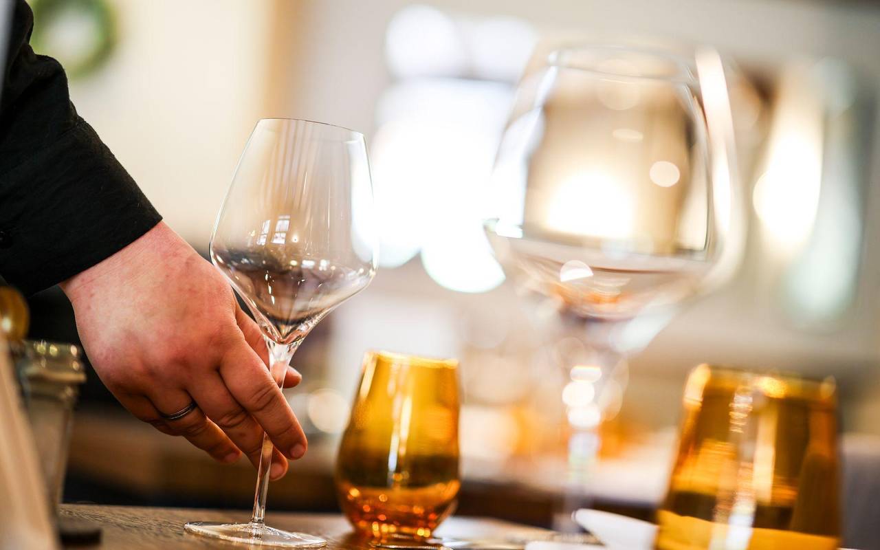 Eine Mitarbeiterin stellt beim Eindecken ein Glas auf