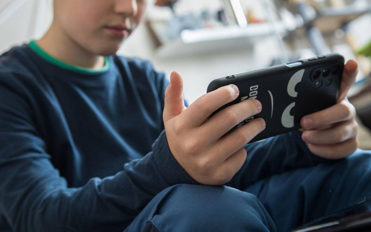 Ein Junge schaut auf sein Smartphone