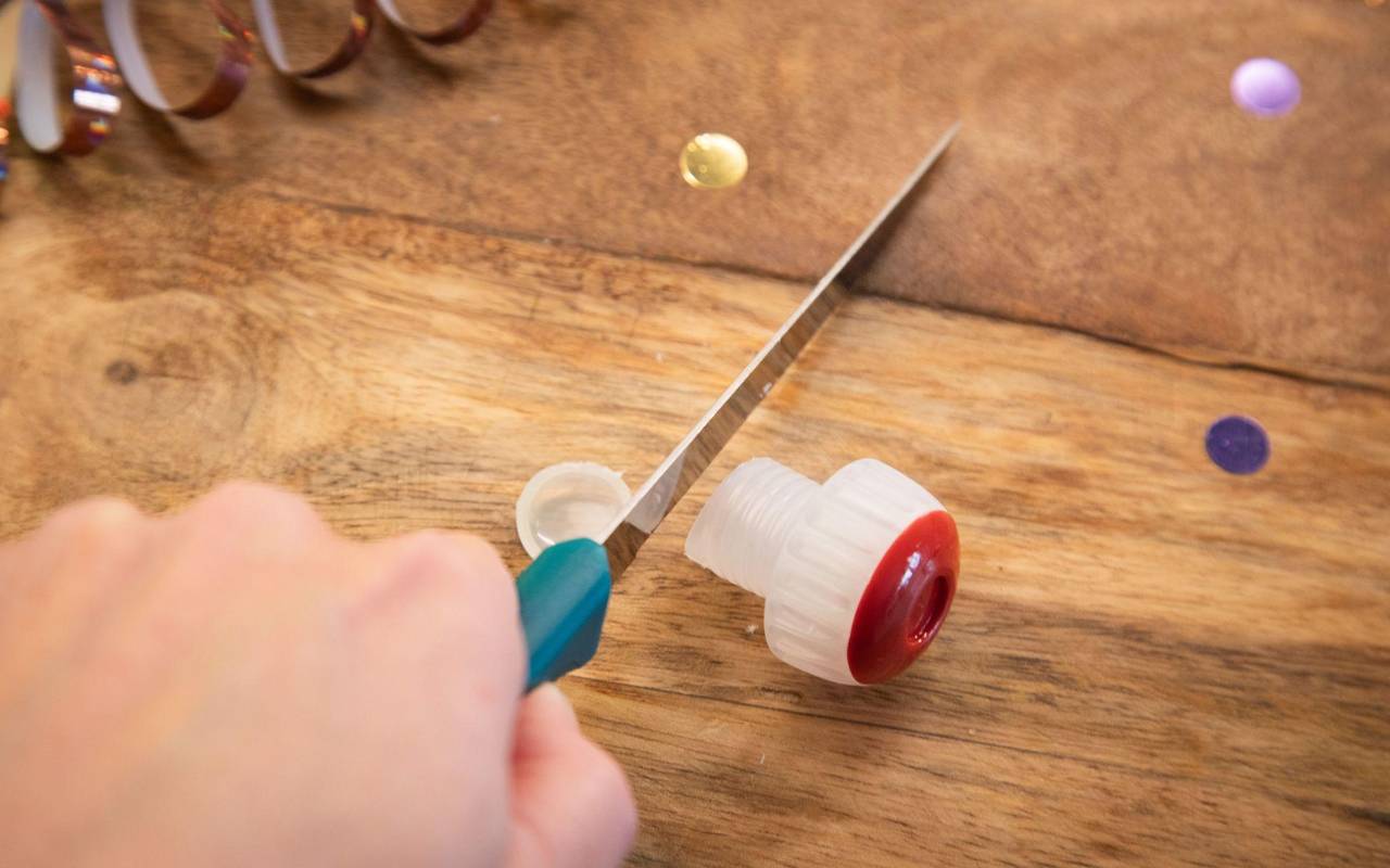 Mit einem Messer wird die Unterseite des Korkens angeschnitten