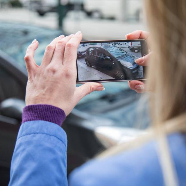 Frau fotografiert ein Auto