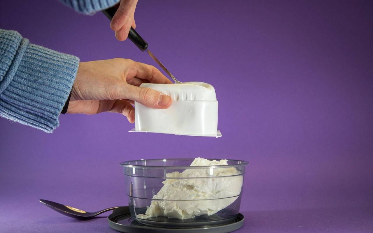 Quark wird aus der Packung in eine Schale gedrückt