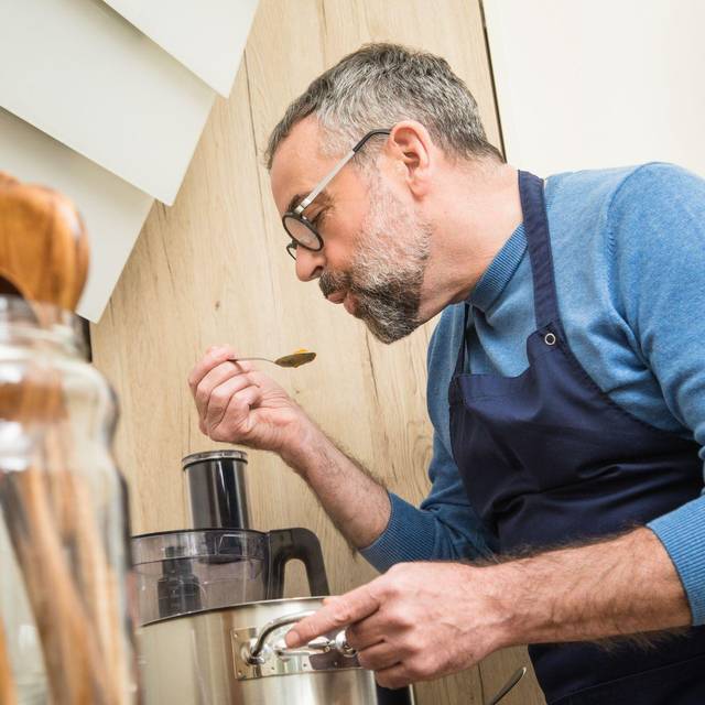 Ein Mann schmeckt ein Gericht ab