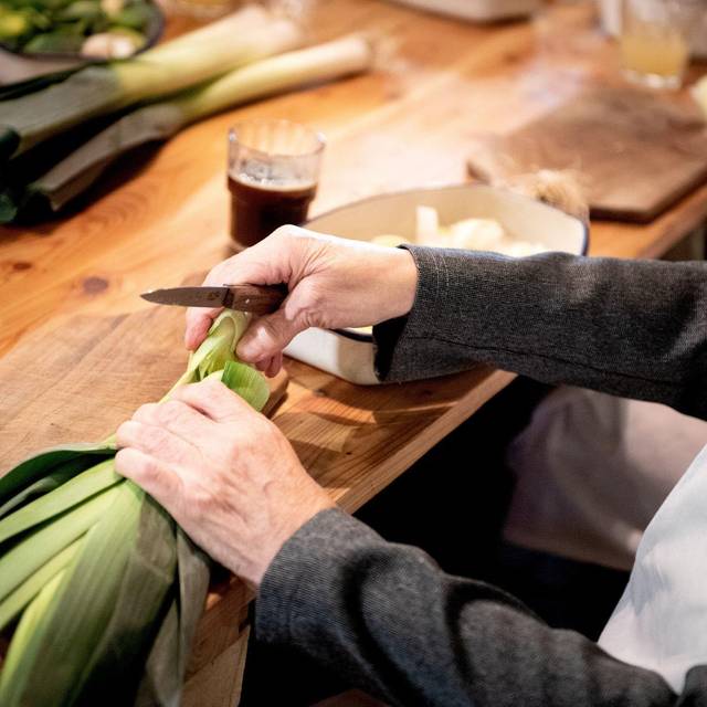Eine Seniorin schneidet Lauch klein