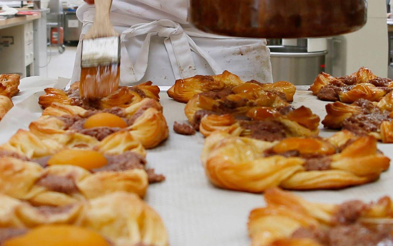 Bäcker glänzt Plundergebäck ab
