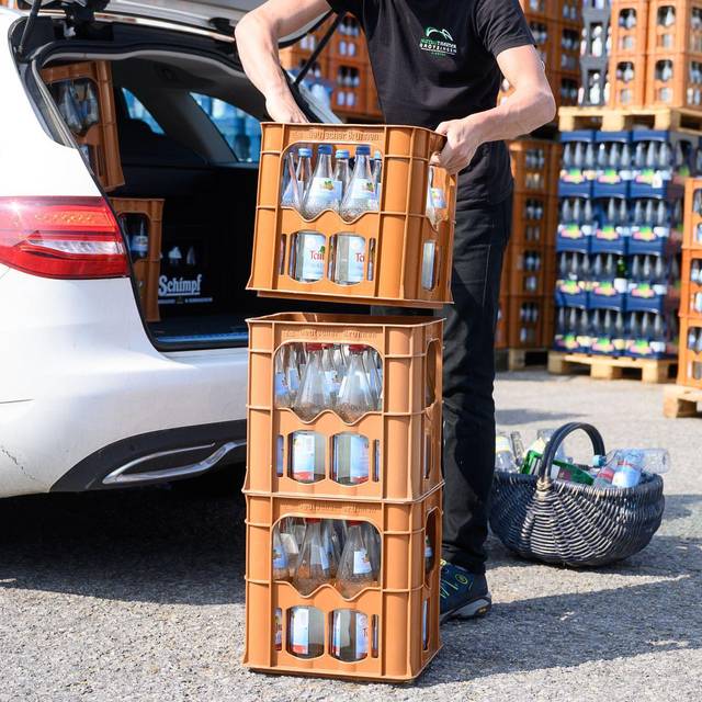 Ein Mann verlädt Mineralwasserkästen