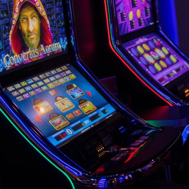 Eine Person sitzt an einem Spielautomaten