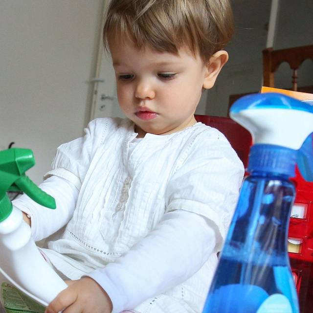 Mädchen spielt mit Putzmitteln