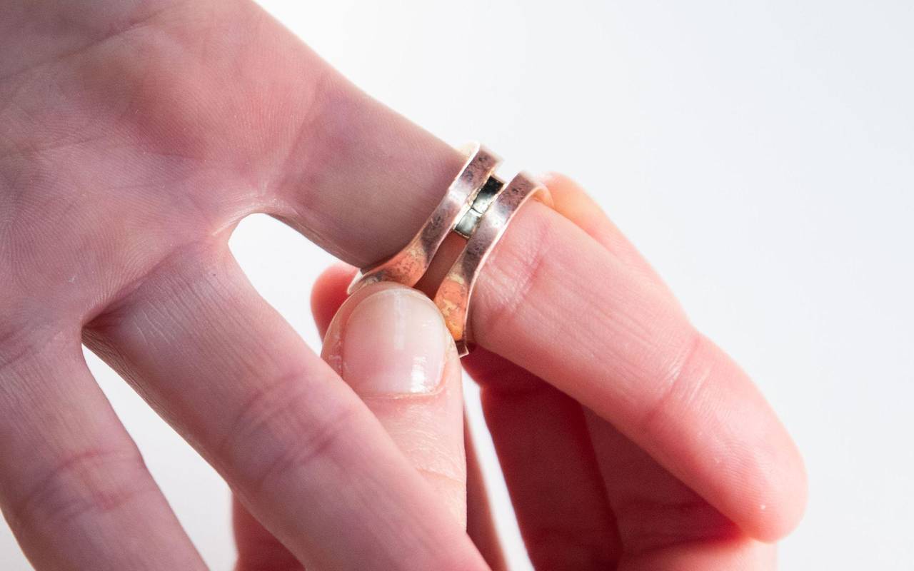 Frau steckt sich einen Ring an den Finger