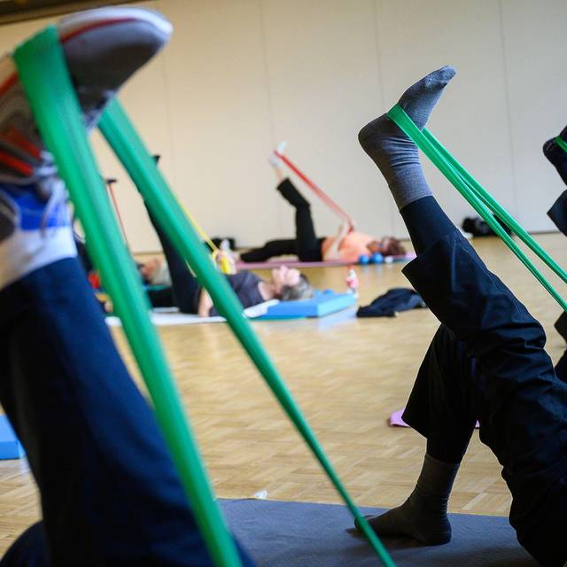 Senioren machen eine Übung mit einem Theraband