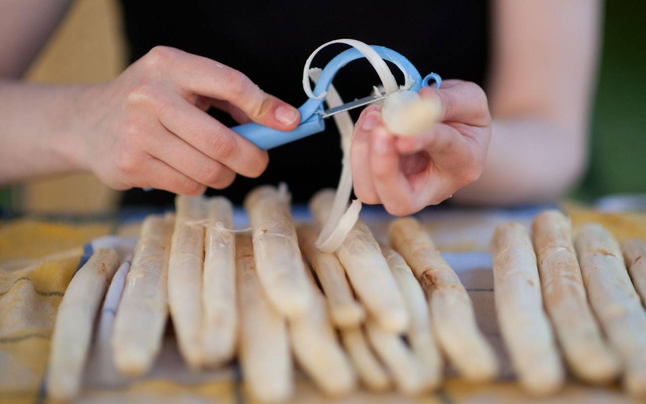 Frau schält Spargel