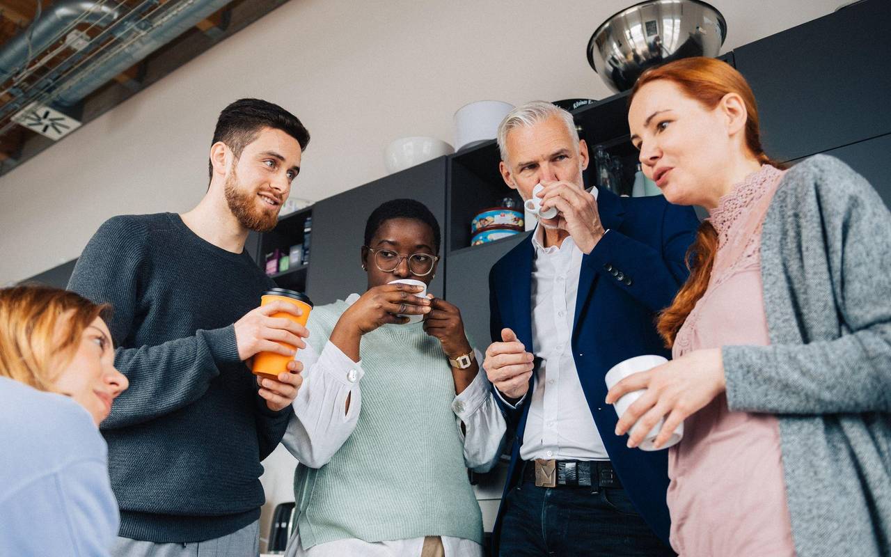 Eine Gruppe Kollegen verbringt ihre Pause in einer Büroküche