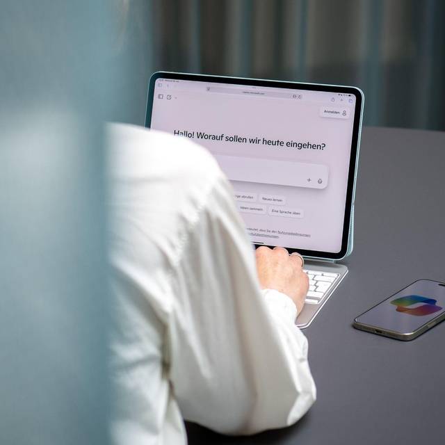 Eine Frau nutzt den KI-Assistenten Microsoft Copilot auf iPad