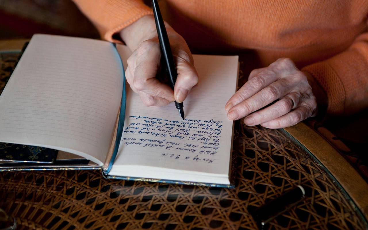 Eine Frau schreibt in ein Notizbuch