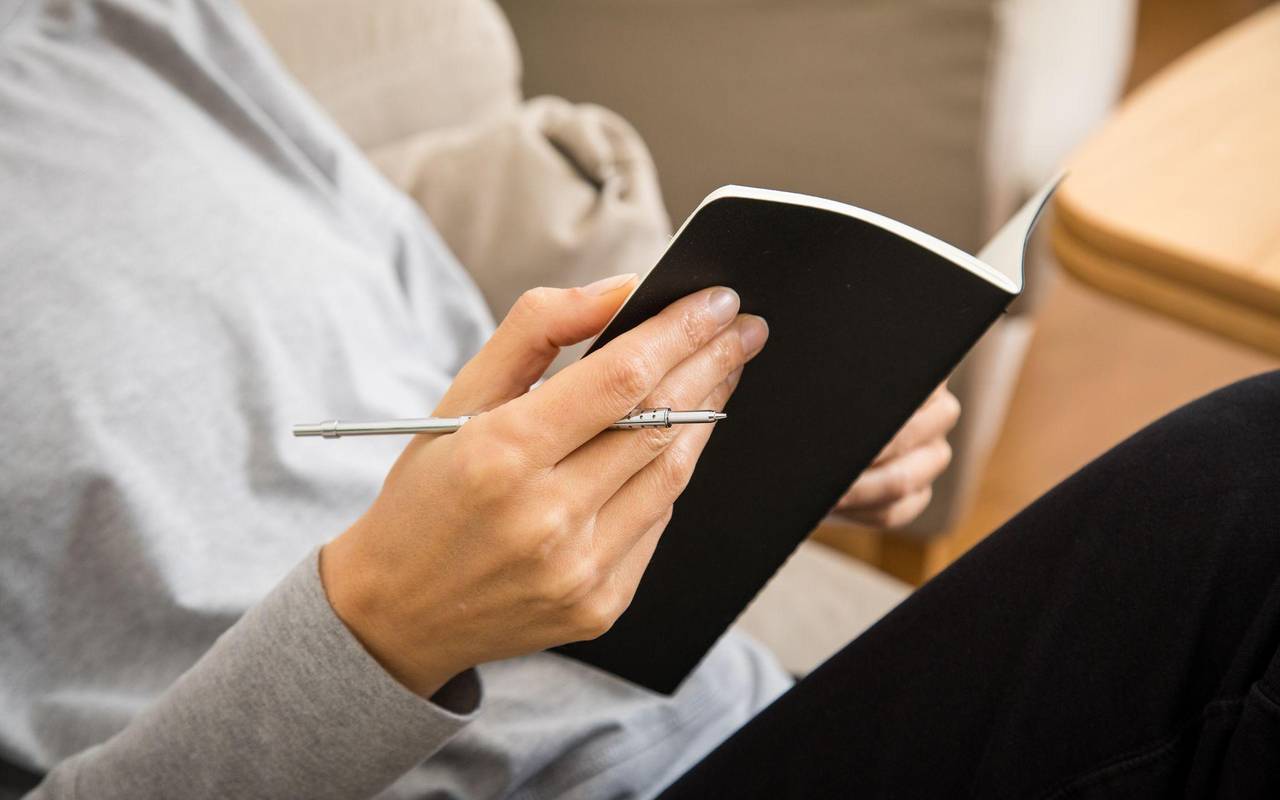 Eine Frau schreibt in ein Heft