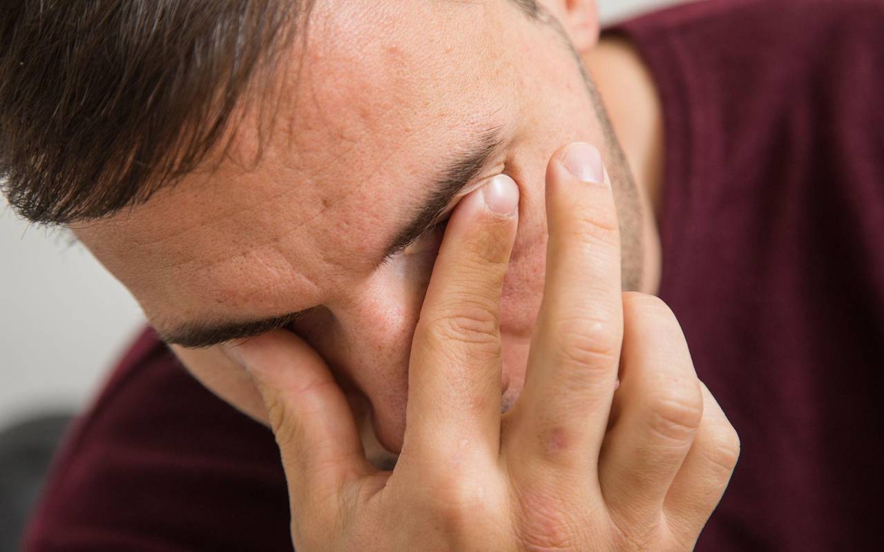 Mann fässt sich an die Augen