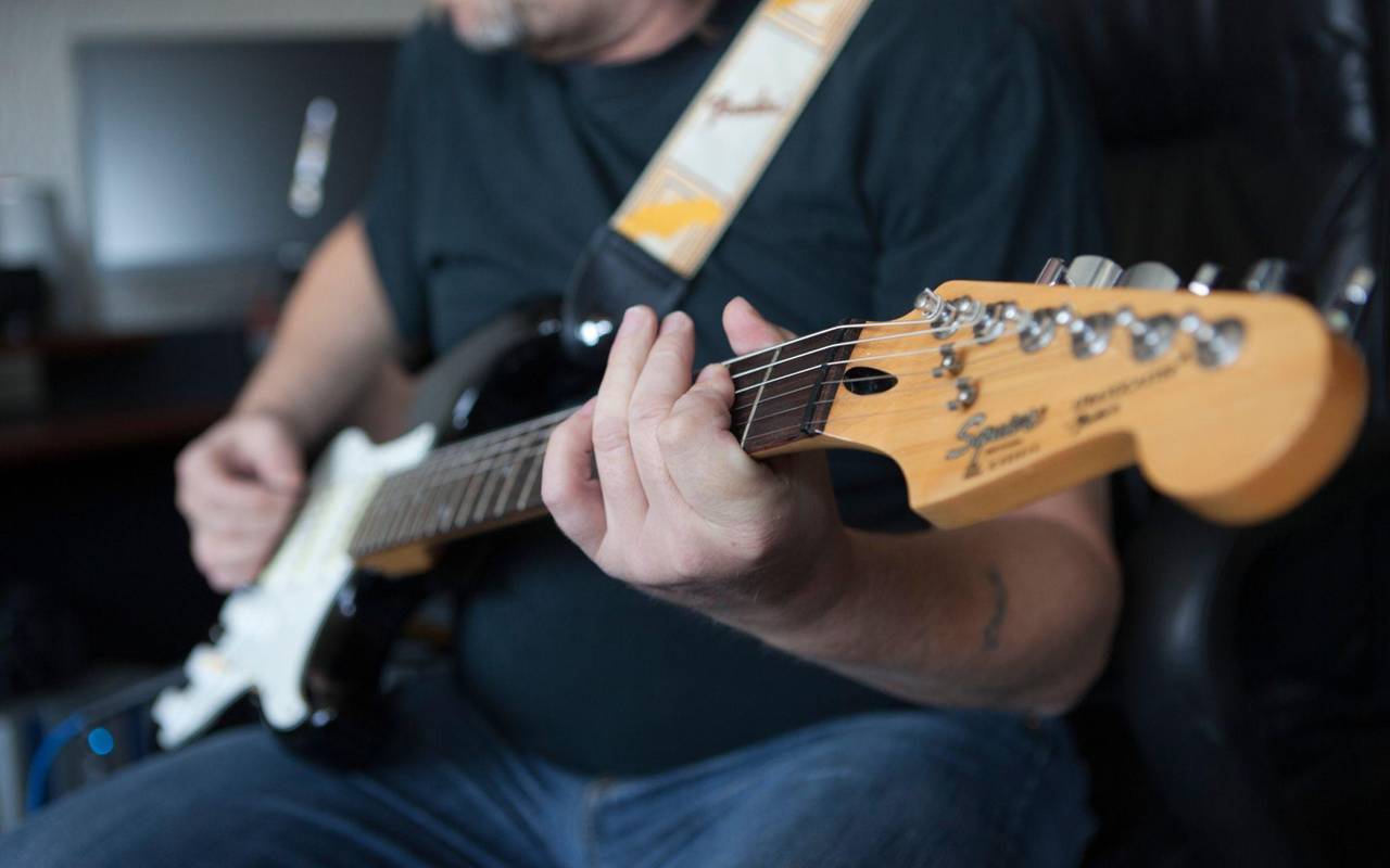 Mann spielt auf einer E-Gitarre