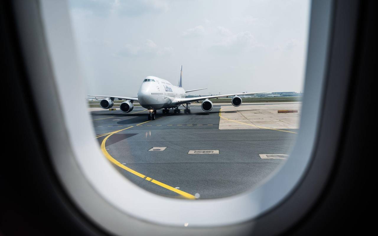 Blick aus einem Flugzeug auf die Rollbahn am Flughafen