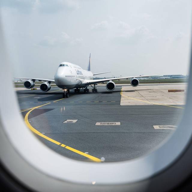 Blick aus einem Flugzeug auf die Rollbahn am Flughafen
