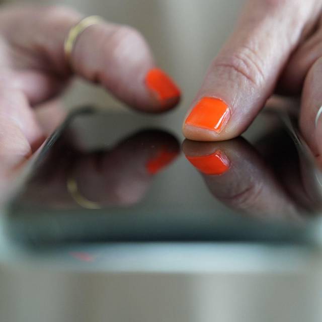 Eine Frau tippt auf einem Smartphone