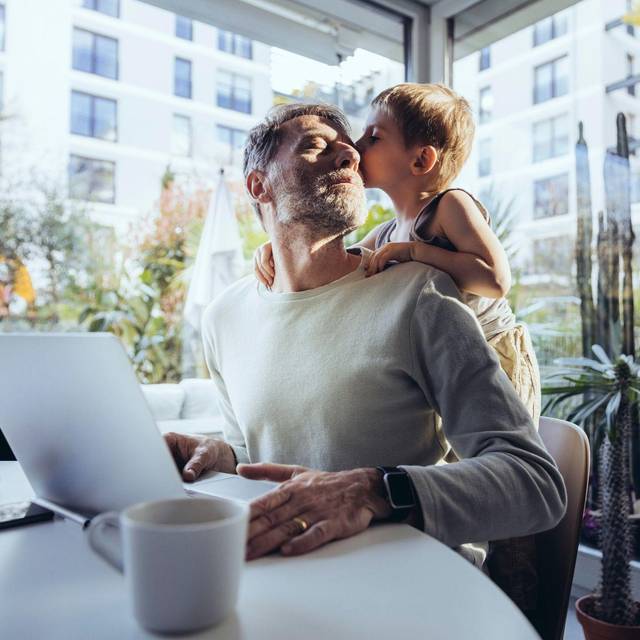 Mann mit Sohn arbeitet im Homeoffice