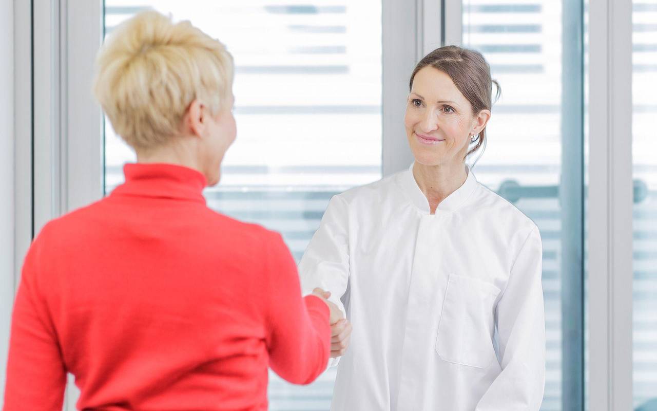 Ärztin begrüßt eine Patientin