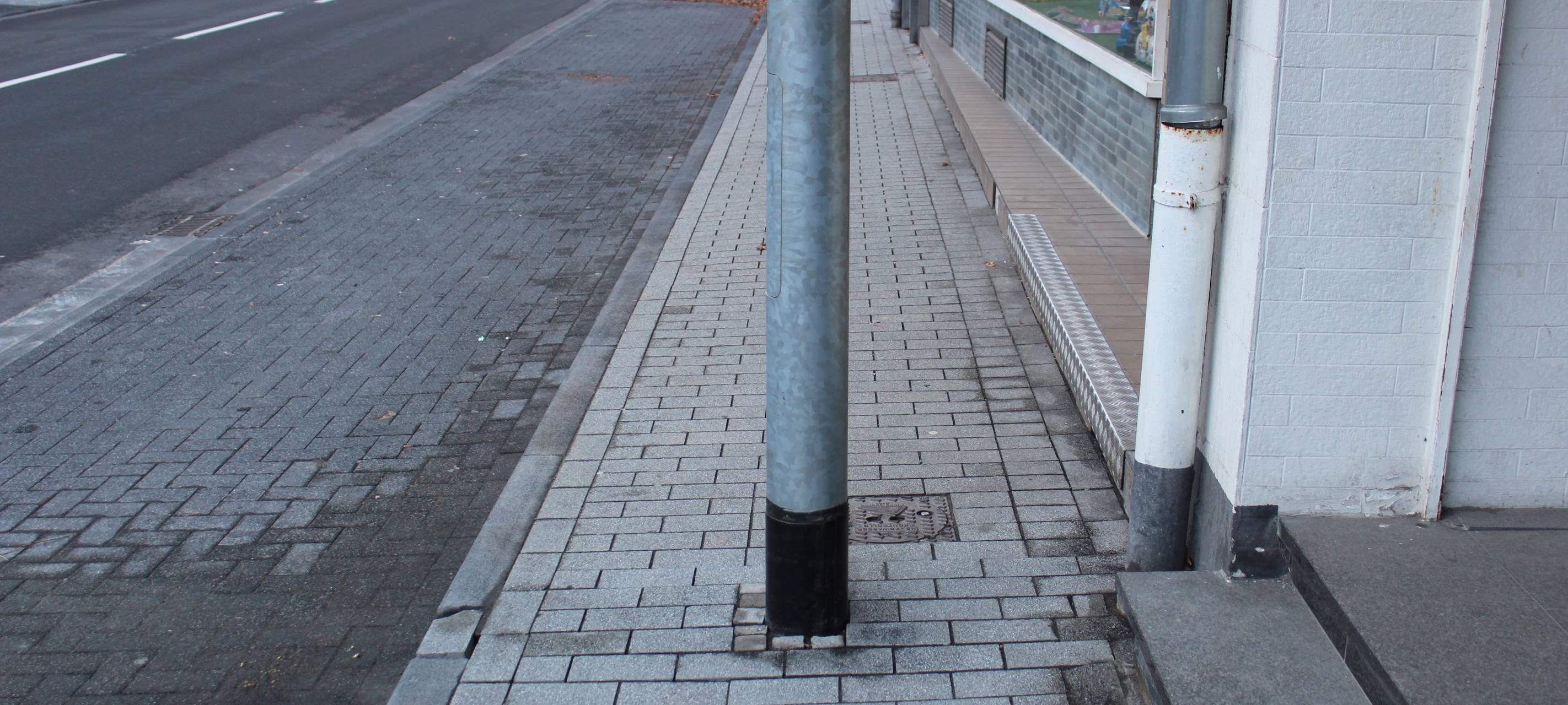 Straßenlaterne steht mitten auf dem Gehweg