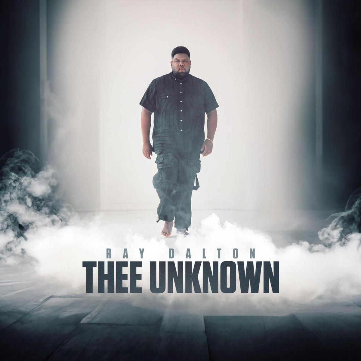 Das Musikcover der Single 'Thee Unknown' von Ray Dalton zeigt ihn Barfuß in schwarzer Kleidung in einem weißen Raum mit Rauch.